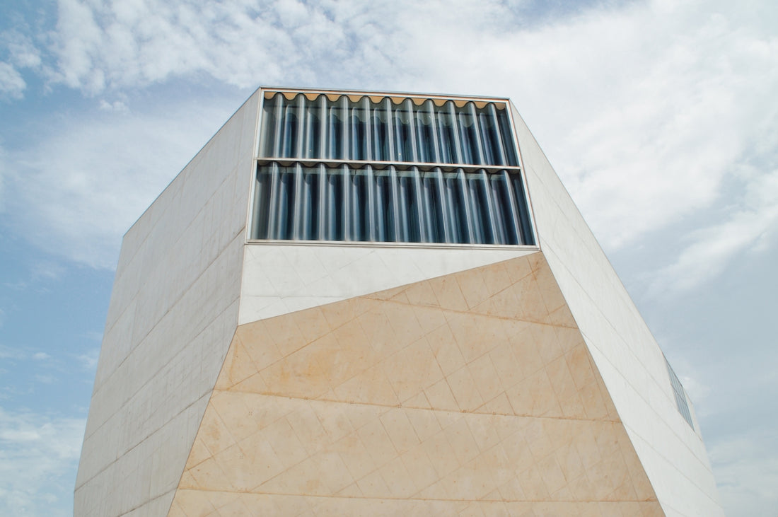 white concrete tall building under cloudy sky