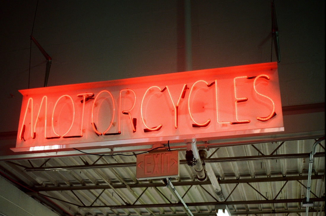a neon sign that reads motorcycles hanging from a ceiling