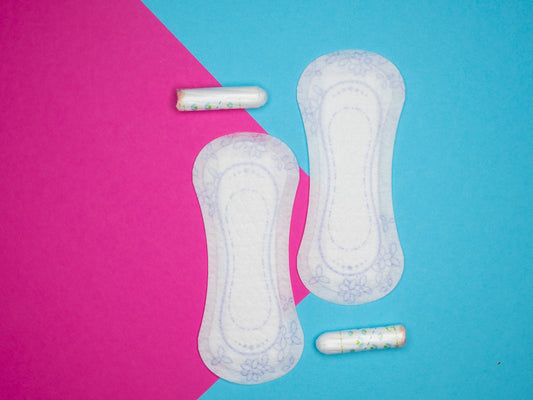 a pair of sanitary pads next to two pills