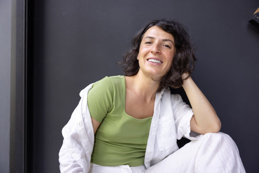 a woman sitting on the floor with her hand on her head
