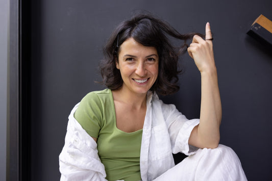 a woman sitting on the floor with a cigarette in her hand